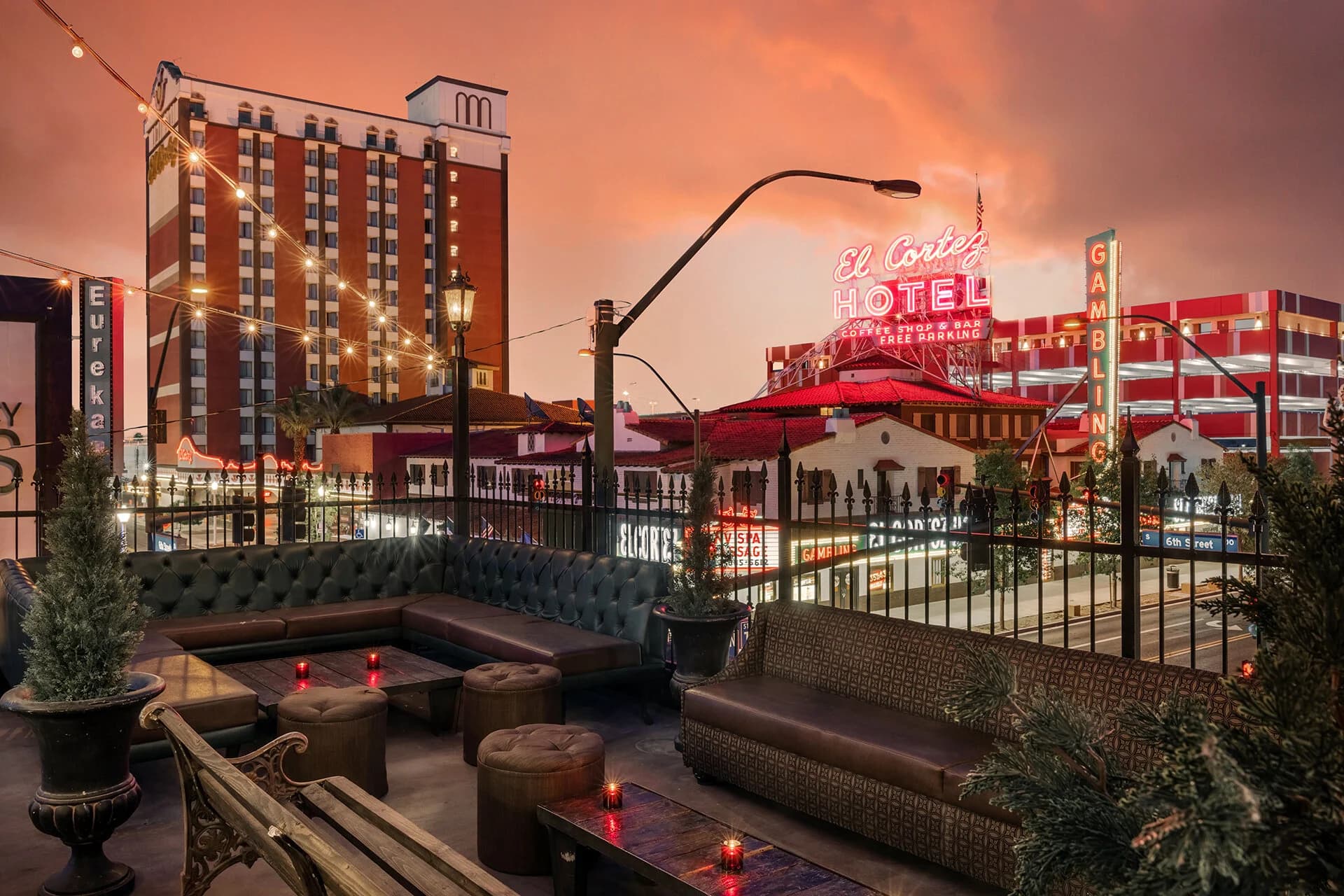 The Commonwealth rooftop at dusk with lounge seating and downtown hotel signs behind it